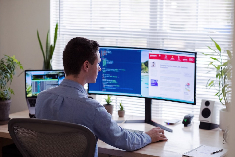 A team leader on a computer at a desk implementing proposal automation.