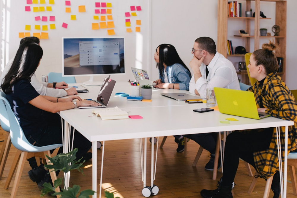 A team in an office discussing PSA software during a meeting